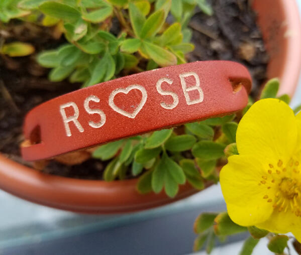 Personalized engraved leather bracelet with initials and heart design.
